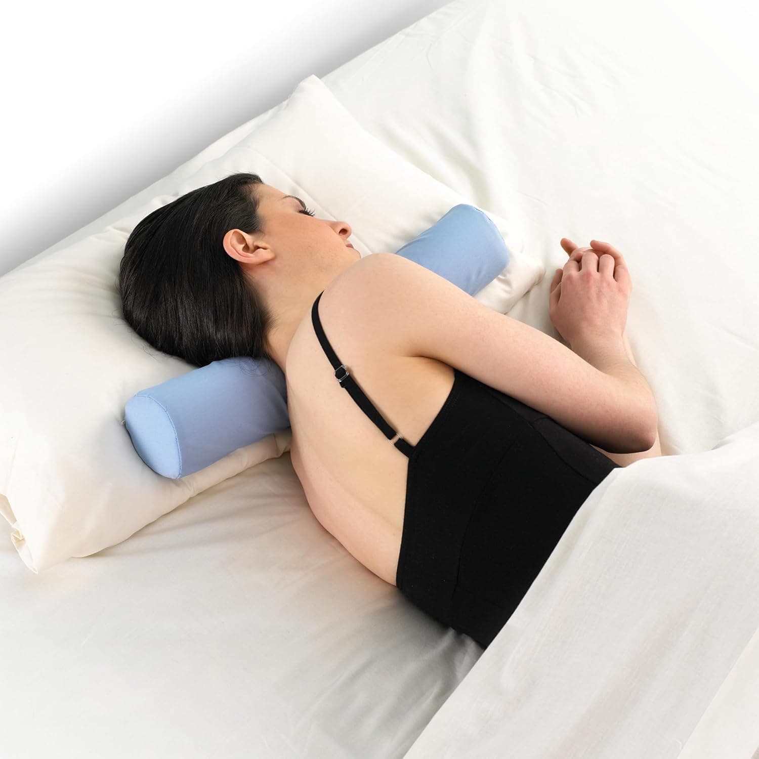 Cervical roll resting against a pillow for sleep support